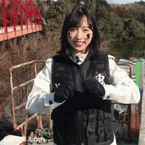 Woman In Black Vest With Letter V Smiling GIF