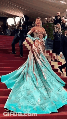 Woman In Blue And Gold Dress Walking Down Stairs GIF