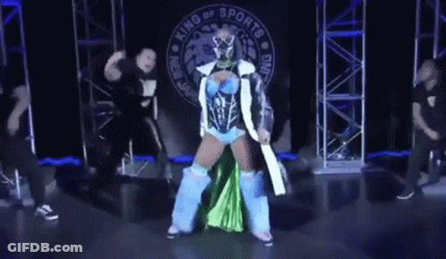 Woman In Blue And Green Outfit In Front Of King Of Sports Banner GIF