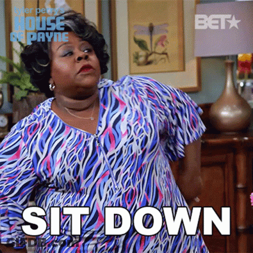 Woman In Blue And Pink Zebra Dress Standing In Front Of Sit Down Sign GIF
