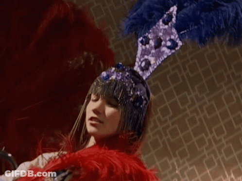 Woman In Blue And Purple Feathered Hat GIF