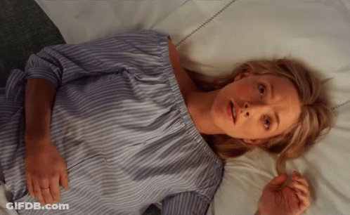 Woman In Blue And White Striped Shirt Laying On Bed GIF
