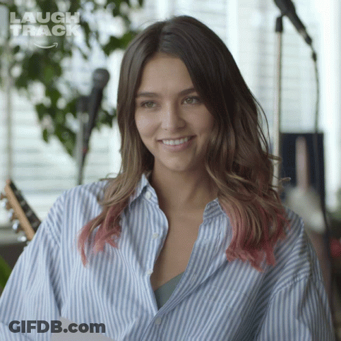 Woman In Blue And White Striped Shirt Smiling At Microphone GIF