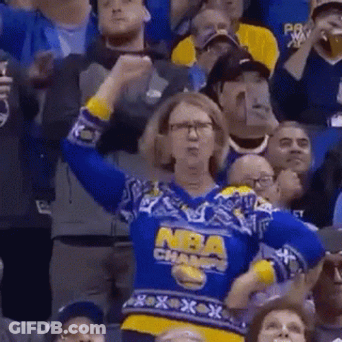 Woman In Blue And Yellow Sweater Cheering At Basketball Game GIF