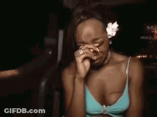 Woman In Blue Bikini Top With Flower In Hair Being Pointed At GIF