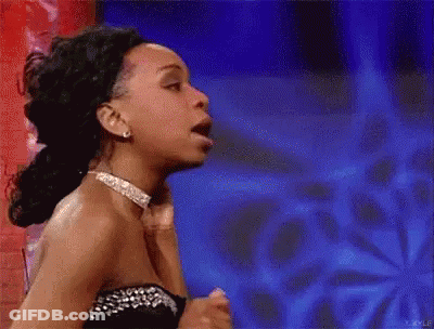 Woman In Blue Bikini Top With Flower In Hair Being Pointed At GIF