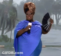 Woman In Blue Cape Holding Fan And Microphone GIF