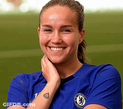 Woman In Blue Chelsea Shirt Smiling With Hand On Face GIF