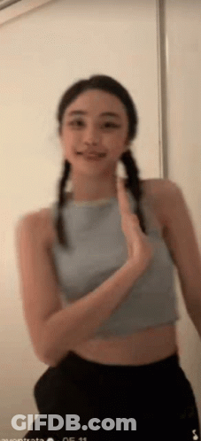 Woman In Blue Crop Top And Black Shorts Smiling Waving GIF