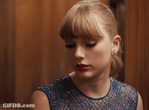 Woman In Blue Dress And Earrings Looking Down GIF