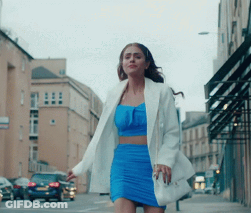 Woman In Blue Dress And White Jacket Walking GIF