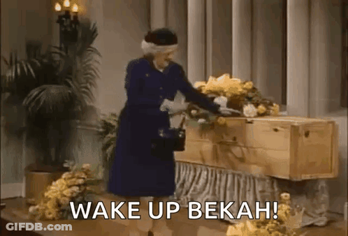 Woman In Blue Dress Beside Coffin With Flowers GIF