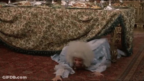 Woman In Blue Dress Crawling Under Table GIF