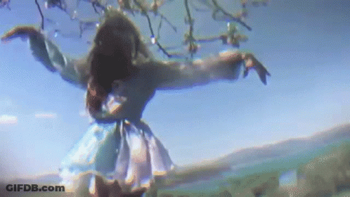 Woman In Blue Dress Dancing Under Tree GIF