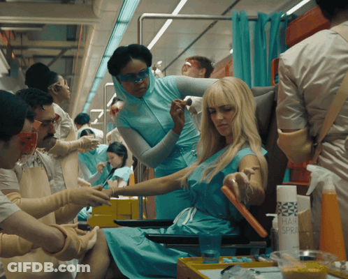 Woman In Blue Dress Getting Hair Styled GIF
