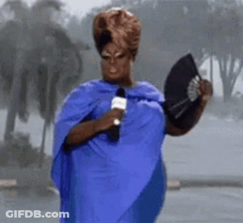 Woman In Blue Dress Holding Microphone And Fan GIF