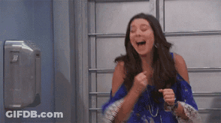 Woman In Blue Dress Laughing And Pumping Fist GIF