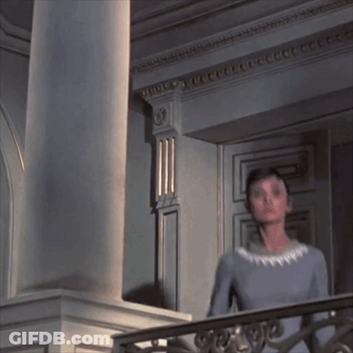 Woman In Blue Dress On Balcony With Columns GIF