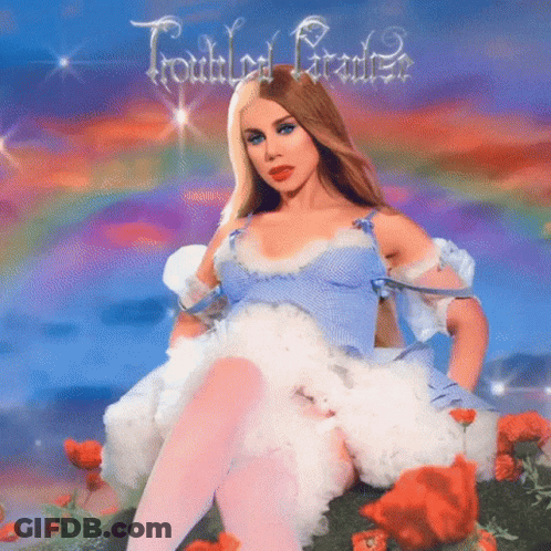 Woman In Blue Dress Sitting In Flower Field GIF