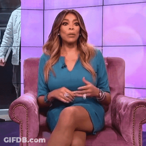 Woman In Blue Dress Sitting With Legs Crossed GIF