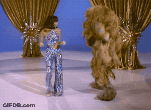 Woman In Blue Dress Standing Before Crowd GIF