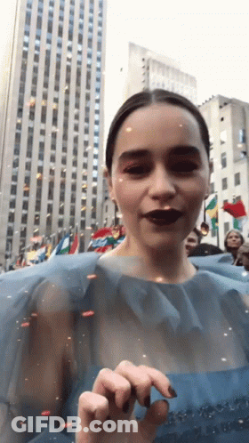 Woman In Blue Dress Standing In Front Of Building GIF