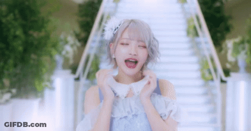 Woman In Blue Dress Standing In Front Of Stairs With Mouth Open GIF