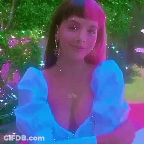 Woman In Blue Dress Standing On Pink Carpet In Park GIF