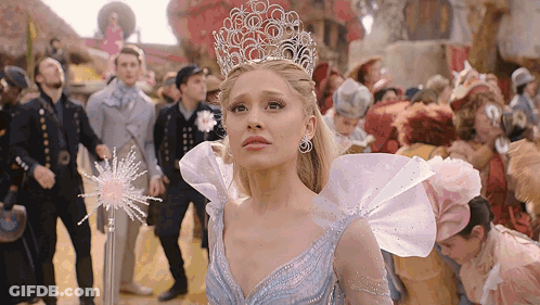 Woman In Blue Dress With Crown Standing In Front Of Crowd GIF