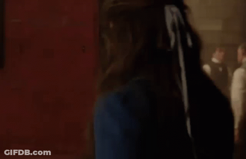 Woman In Blue Dress With Man In Suit Behind Her GIF