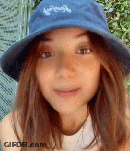 Woman In Blue Hat And White Shirt Smiling GIF