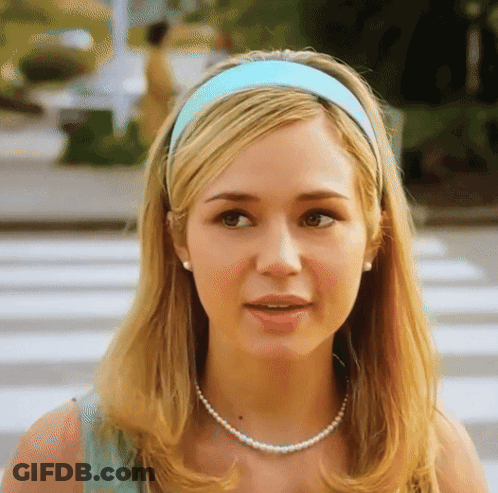 Woman In Blue Headband And Pearls Looking At Camera GIF