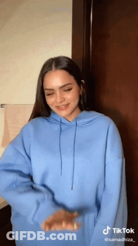 Woman In Blue Hoodie Smiling And Dancing GIF