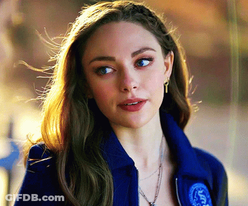 Woman In Blue Jacket And Earrings Looking At Camera GIF