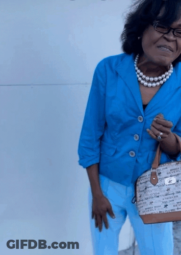 Woman In Blue Jacket And Pearls Holding Beverly Hills Bag GIF