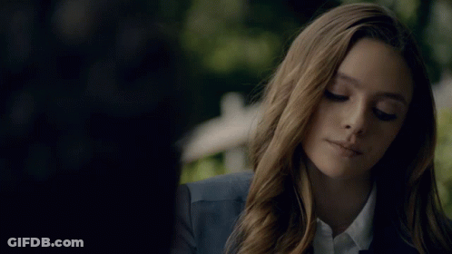 Woman In Blue Jacket And White Shirt Looking Down GIF