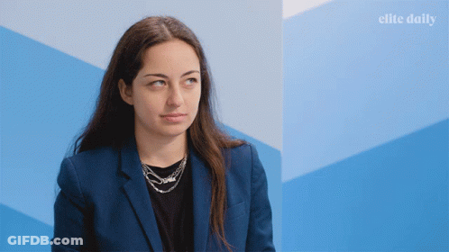 Woman In Blue Jacket By Blue Wall With Elite Daily GIF