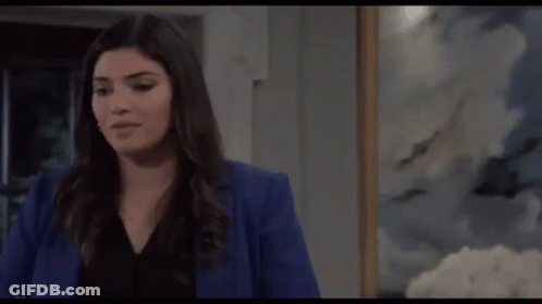 Woman In Blue Jacket In Front Of Painting GIF