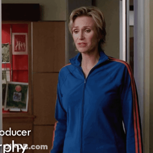 Woman In Blue Jacket In Front Of Producer Graphy Sign GIF
