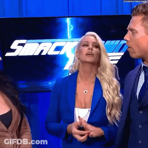 Woman In Blue Jacket In Front Of SmackDown Logo GIF