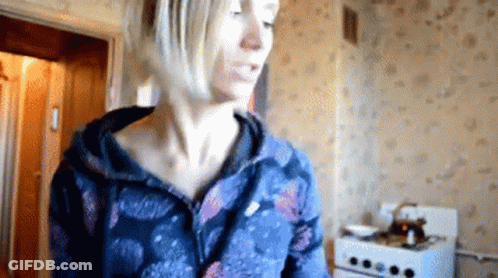 Woman In Blue Jacket In Kitchen GIF