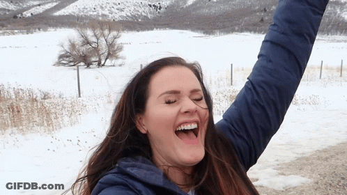 Woman In Blue Jacket Laughing Arms Up GIF