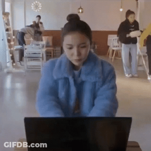 Woman In Blue Jacket Typing On Laptop GIF
