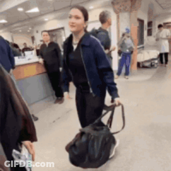 Woman In Blue Jacket Walking With Black Bag GIF