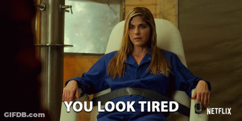 Woman In Blue Jumpsuit Sitting Says You Look Tired GIF