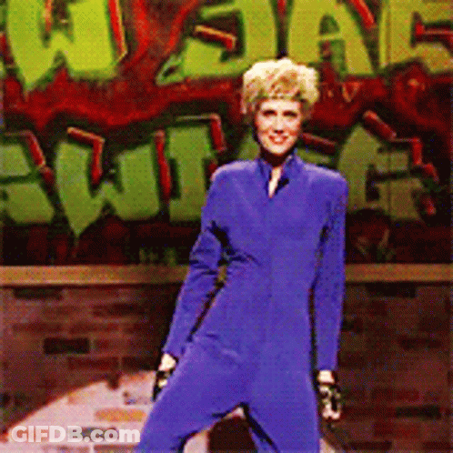 Woman In Blue Jumpsuit With Graffiti Saying What GIF