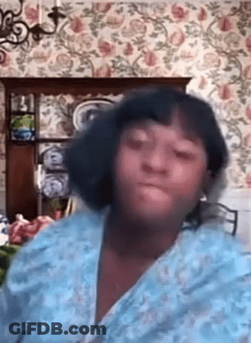 Woman In Blue Robe Sitting With Floral Wallpaper GIF