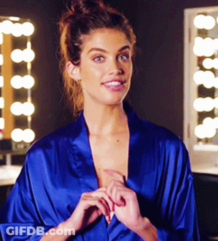 Woman In Blue Robe Smiling In Mirror GIF