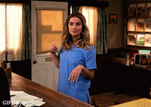 Woman In Blue Scrub Top At Door GIF