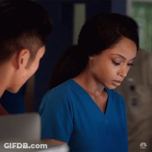 Woman In Blue Scrubs Looking At Man GIF